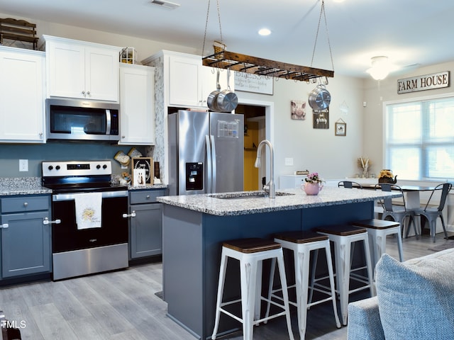 1419 New Daniels Chapel Rd, Fremont, NC 27830 - kitchen with appliances with stainless steel finishes, a sink, a kitchen bar, an island with sink, and light wood finished floors
