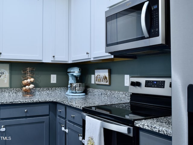 1419 New Daniels Chapel Rd, Fremont, NC 27830 - kitchen with stainless steel appliances, white cabinets, and light stone counters