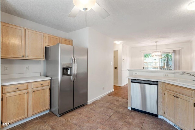 205 Mint Hill Dr, Cary, NC 27519 - kitchen with stainless steel appliances, light brown cabinets, a ceiling fan, a chandelier, and light countertops