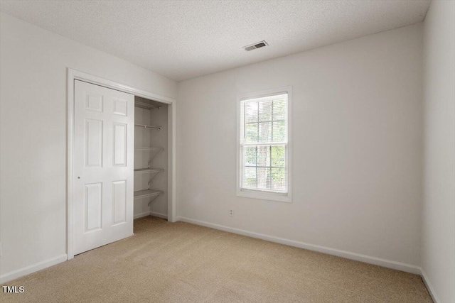 205 Mint Hill Dr, Cary, NC 27519 - unfurnished bedroom featuring light colored carpet, a textured ceiling, and a closet