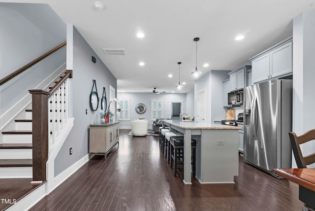1448 Big Falls Dr, Wendell, NC 27591 - kitchen featuring stainless steel fridge with ice dispenser, black microwave, open floor plan, a breakfast bar, and a center island with sink