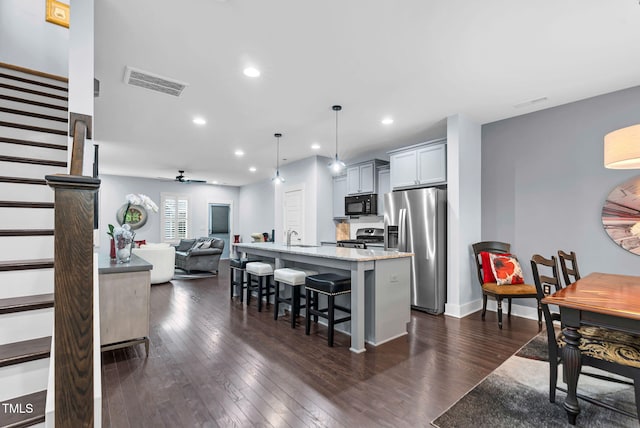 1448 Big Falls Dr, Wendell, NC 27591 - kitchen featuring appliances with stainless steel finishes, a breakfast bar, dark wood-type flooring, a kitchen island with sink, and open floor plan