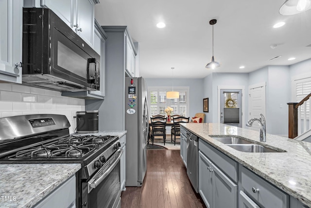 1448 Big Falls Dr, Wendell, NC 27591 - kitchen featuring stainless steel appliances, a sink, gray cabinetry, dark wood-style floors, and backsplash