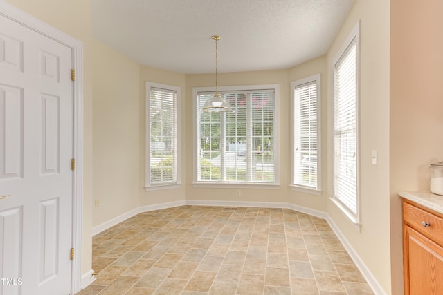 2026 Heritage Pines Dr, Cary, NC 27519 - unfurnished dining area featuring plenty of natural light, light stone finish floors, and a textured ceiling