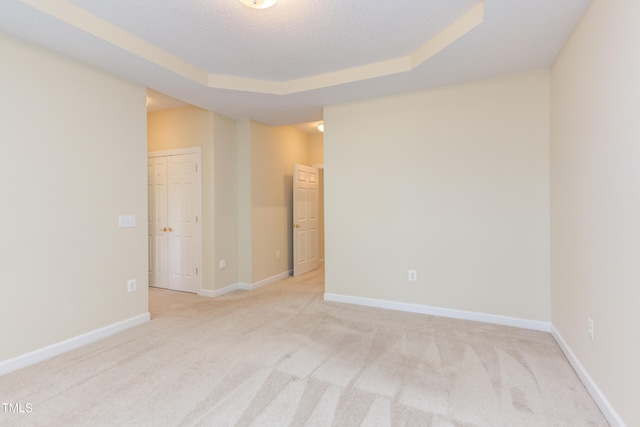 2026 Heritage Pines Dr, Cary, NC 27519 - spare room featuring light carpet, a textured ceiling, and a tray ceiling