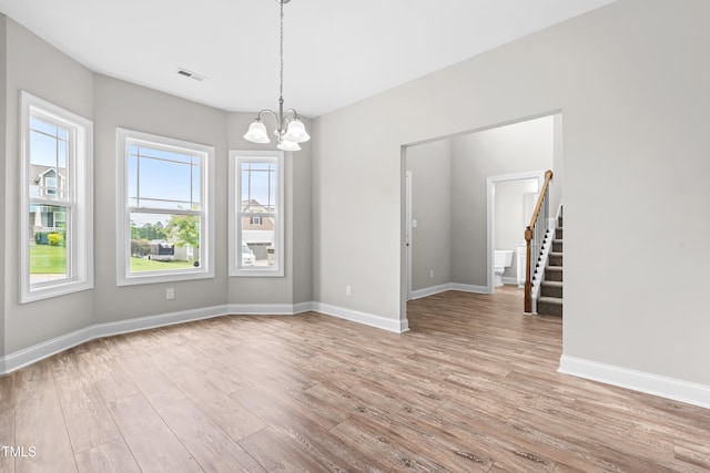 44 Good Morning Ln, Garner, NC 27529 - unfurnished room featuring stairs, healthy amount of natural light, a chandelier, and light wood-style floors