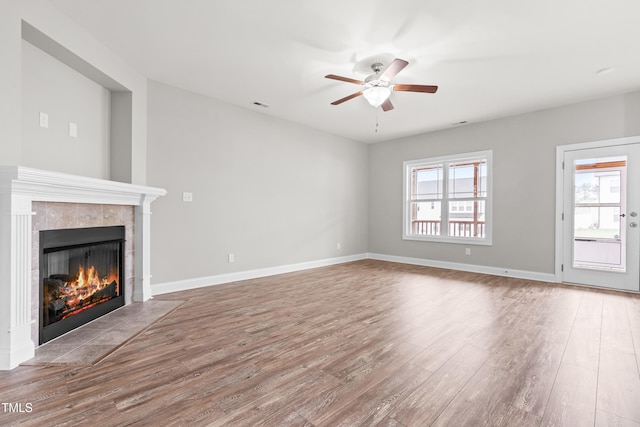 44 Good Morning Ln, Garner, NC 27529 - unfurnished living room with healthy amount of natural light, a tiled fireplace, and wood finished floors