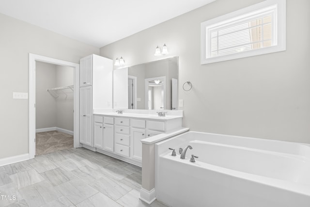 44 Good Morning Ln, Garner, NC 27529 - bathroom featuring double vanity, a bath, baseboards, and a spacious closet