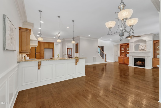 104 Bellagio Dr, Apex, NC 27539 - kitchen with a peninsula, recessed lighting, a large fireplace, ornamental molding, and built in shelves