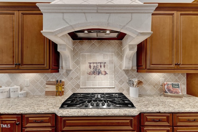 104 Bellagio Dr, Apex, NC 27539 - kitchen with stainless steel gas cooktop, tasteful backsplash, brown cabinets, and range hood