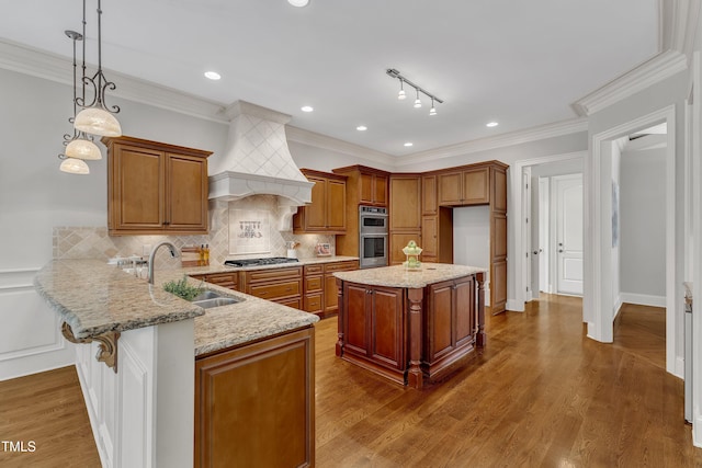104 Bellagio Dr, Apex, NC 27539 - kitchen featuring a sink, light stone counters, brown cabinetry, a peninsula, and tasteful backsplash