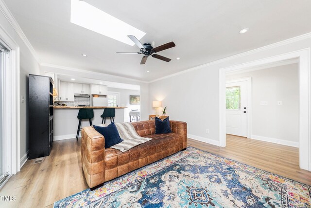 2968 Tram Rd, Fuquay Varina, NC 27526 - living area featuring light wood finished floors, ceiling fan, baseboards, crown molding, and recessed lighting