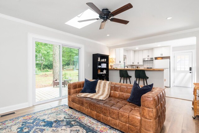 2968 Tram Rd, Fuquay Varina, NC 27526 - living area featuring a ceiling fan, ornamental molding, light wood-style flooring, a skylight, and recessed lighting