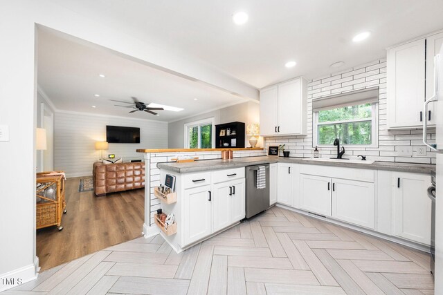 2968 Tram Rd, Fuquay Varina, NC 27526 - kitchen featuring a sink, stainless steel dishwasher, a peninsula, open floor plan, and plenty of natural light