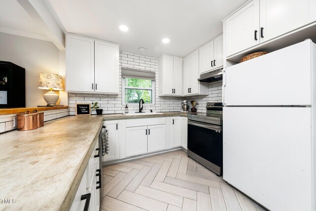 2968 Tram Rd, Fuquay Varina, NC 27526 - kitchen featuring freestanding refrigerator, stainless steel electric range, under cabinet range hood, a sink, and tasteful backsplash
