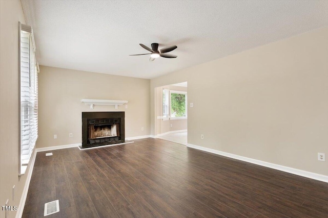 71 E Boxley Dr, Wendell, NC 27591 - unfurnished living room featuring a ceiling fan, dark wood-style flooring, a fireplace with raised hearth, baseboards, and a textured ceiling