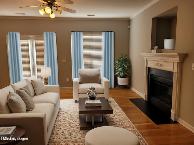 4202 Cherry Blossom Cir, Durham, NC 27713 - living room featuring light wood finished floors, ceiling fan, baseboards, a fireplace with flush hearth, and crown molding