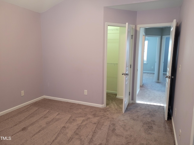 4202 Cherry Blossom Cir, Durham, NC 27713 - unfurnished bedroom featuring carpet floors, a walk in closet, baseboards, and a closet
