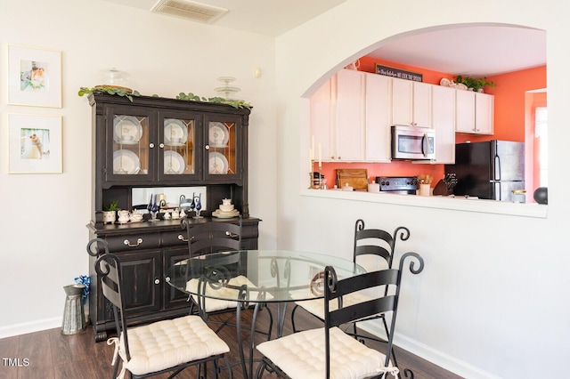 610 Walnut Woods Dr, Morrisville, NC 27560 - dining area with arched walkways, wood finished floors, and baseboards