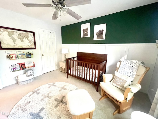 610 Walnut Woods Dr, Morrisville, NC 27560 - carpeted bedroom featuring a nursery area, a ceiling fan, a wainscoted wall, and a decorative wall