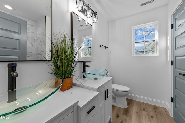2513 Rochelle St, Durham, NC 27703 - bathroom featuring vanity, wood finished floors, toilet, baseboards, and recessed lighting
