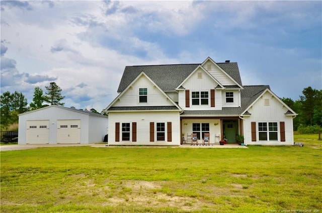 1865 John B Carter Rd, Fayetteville, NC 28312 - view of front facade with board and batten siding, a garage, roof with shingles, a front lawn, and an outdoor structure