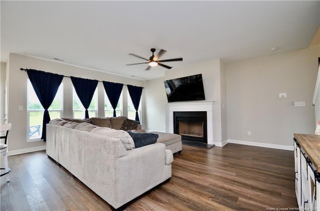 1865 John B Carter Rd, Fayetteville, NC 28312 - living area with ceiling fan, dark wood-style floors, a fireplace with raised hearth, and baseboards
