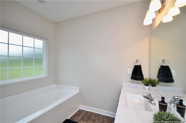 1865 John B Carter Rd, Fayetteville, NC 28312 - bathroom with wood finished floors, double vanity, a bath, and baseboards