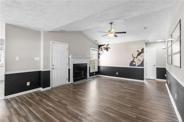 1419 Acacia Dr, Fayetteville, NC 28314 - unfurnished living room with wood finished floors, vaulted ceiling, ceiling fan, a textured ceiling, and a glass covered fireplace