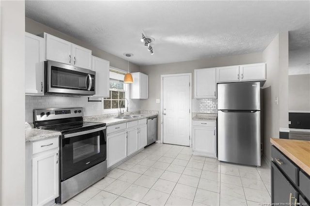 1419 Acacia Dr, Fayetteville, NC 28314 - kitchen with appliances with stainless steel finishes, light countertops, a sink, white cabinets, and a textured ceiling