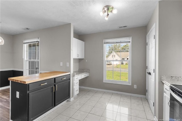 1419 Acacia Dr, Fayetteville, NC 28314 - kitchen with dark cabinets, baseboards, wooden counters, light marble finish flooring, and white cabinets