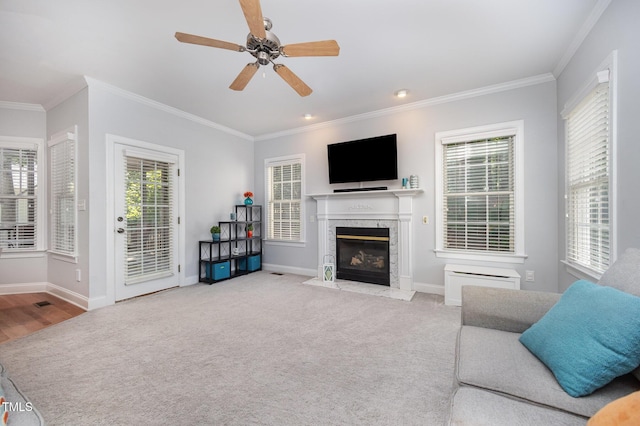 804 Town Side Dr, Apex, NC 27502 - carpeted living room featuring crown molding, a high end fireplace, plenty of natural light, and a ceiling fan