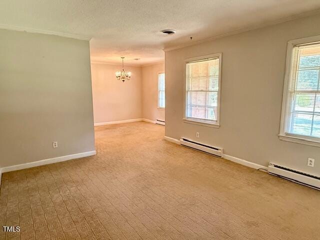 1007 Driftwood Dr, Siler City, NC 27344 - empty room featuring a baseboard heating unit, a chandelier, ornamental molding, and plenty of natural light