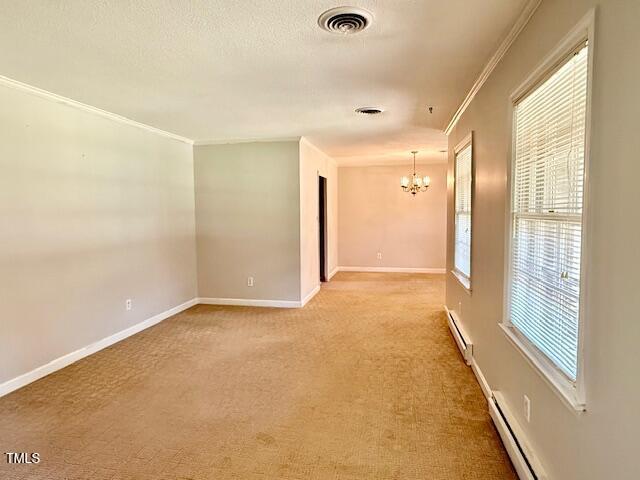 1007 Driftwood Dr, Siler City, NC 27344 - spare room featuring a chandelier, a baseboard radiator, crown molding, and light colored carpet