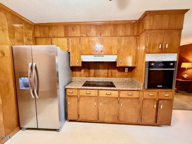 1007 Driftwood Dr, Siler City, NC 27344 - kitchen with black appliances, under cabinet range hood, brown cabinetry, a textured ceiling, and light stone countertops