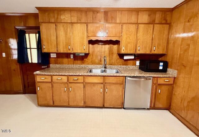 1007 Driftwood Dr, Siler City, NC 27344 - kitchen with dishwasher, black microwave, wood walls, brown cabinets, and light countertops