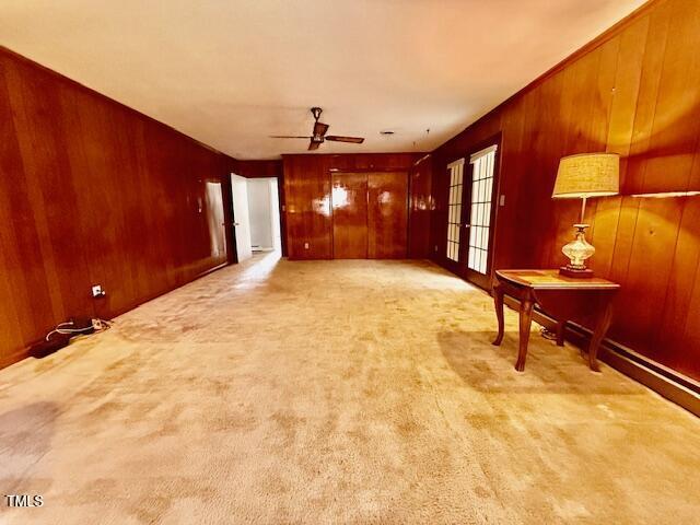 1007 Driftwood Dr, Siler City, NC 27344 - unfurnished living room featuring wood walls, a ceiling fan, and carpet floors
