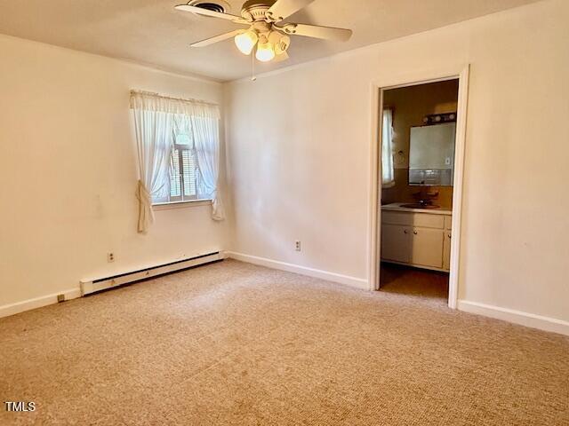 1007 Driftwood Dr, Siler City, NC 27344 - spare room with a baseboard heating unit, light colored carpet, and ceiling fan