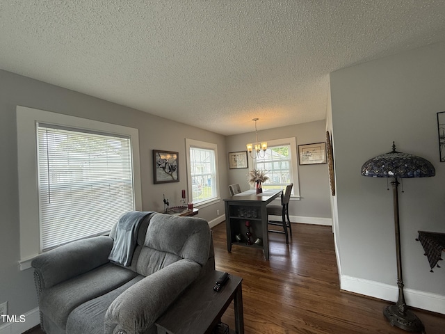 306 W Canary St, Dunn, NC 28334 - living room featuring a chandelier, a textured ceiling, dark wood-type flooring, and baseboards