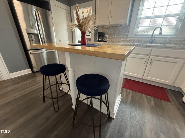 306 W Canary St, Dunn, NC 28334 - kitchen featuring stainless steel refrigerator with ice dispenser, butcher block countertops, dark wood-type flooring, and white cabinetry