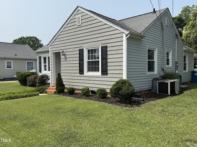 306 W Canary St, Dunn, NC 28334 - view of front of house with cooling unit, a front lawn, and roof with shingles