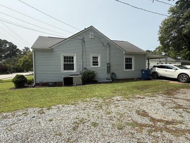306 W Canary St, Dunn, NC 28334 - view of side of home with central AC unit, driveway, a yard, and a shingled roof