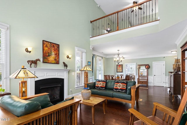 215 Dungarven Loop, Cary, NC 27513 - living area featuring ornamental molding, a chandelier, wood finished floors, a fireplace, and a towering ceiling