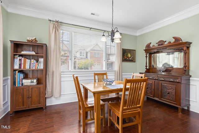 215 Dungarven Loop, Cary, NC 27513 - dining space featuring a chandelier, ornamental molding, dark wood finished floors, a decorative wall, and a wainscoted wall