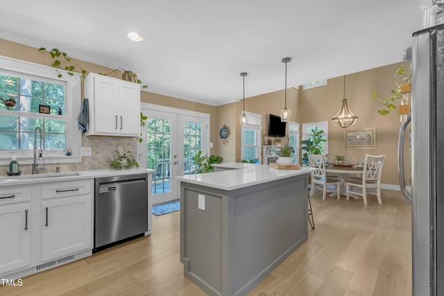 115 E Seve Ct, Morrisville, NC 27560 - kitchen featuring stainless steel appliances, a sink, white cabinets, light wood-style floors, and light countertops