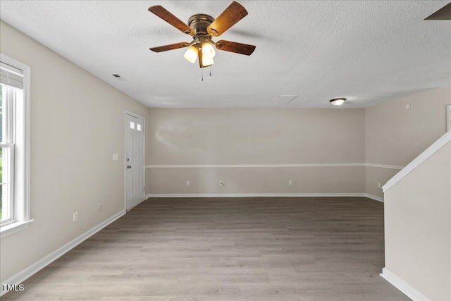 2228 Walnut Ridge Ct, Raleigh, NC 27610 - empty room with plenty of natural light, a textured ceiling, light wood-style floors, ceiling fan, and baseboards