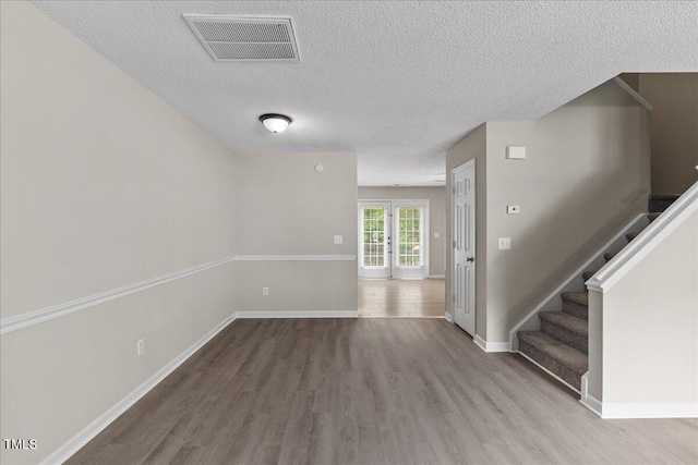 2228 Walnut Ridge Ct, Raleigh, NC 27610 - empty room featuring wood finished floors, a textured ceiling, stairs, and baseboards