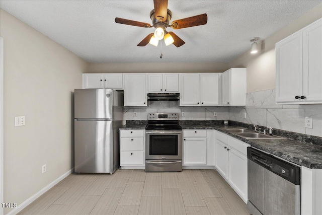 2228 Walnut Ridge Ct, Raleigh, NC 27610 - kitchen featuring appliances with stainless steel finishes, a sink, under cabinet range hood, dark countertops, and white cabinets