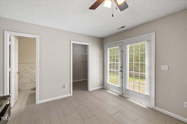 2228 Walnut Ridge Ct, Raleigh, NC 27610 - unfurnished bedroom featuring access to exterior, a spacious closet, baseboards, french doors, and a textured ceiling