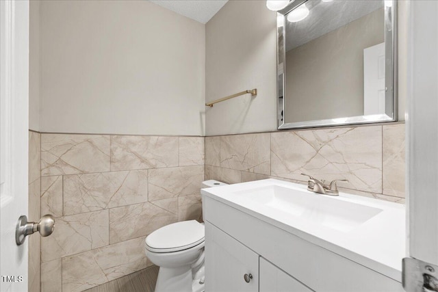 2228 Walnut Ridge Ct, Raleigh, NC 27610 - bathroom featuring vanity, tile walls, toilet, and a wainscoted wall